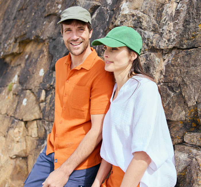 Homme portant une chemise orange en gaze de coton et femme portant une blouse blanche en gaze de coton