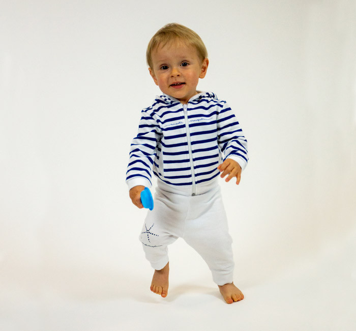 Baby wearing white pants and striped cardigan