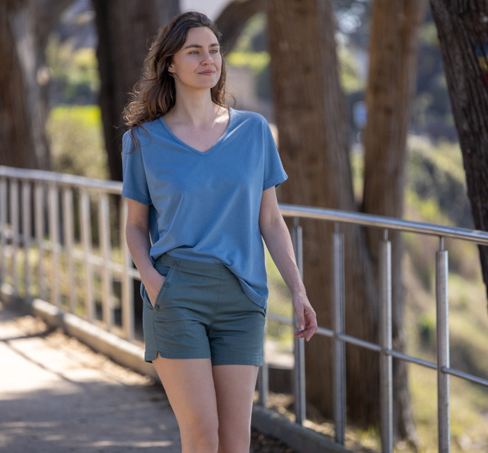 Woman wearing white shorts and a green short-sleeved polo shirt