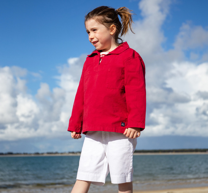 Enfant portant une vareuse en toile rouge