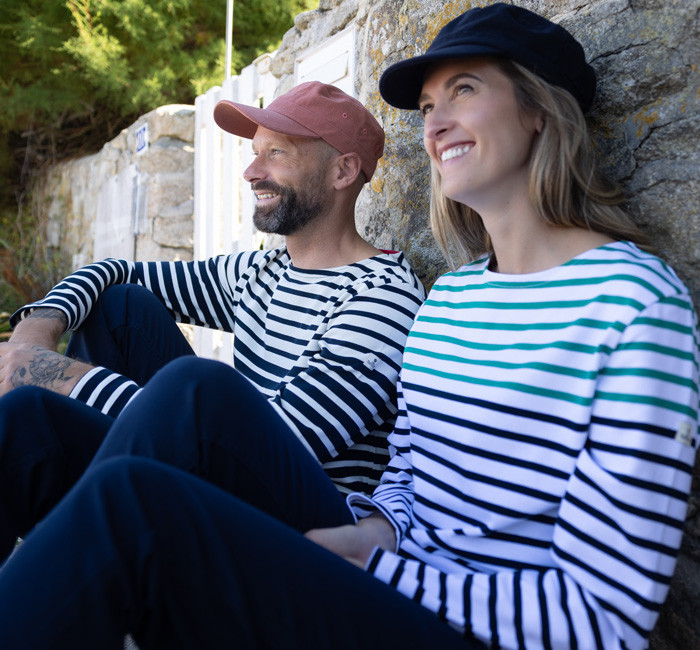 Man and woman wearing breton stripe t-shirts in front of the sunset