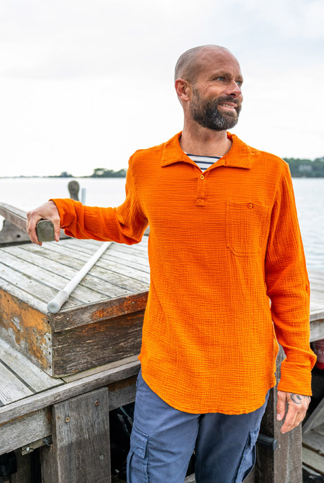 Homme portant une chemise à manches longues orange en gaze de coton Mousqueton par-dessus une marinière