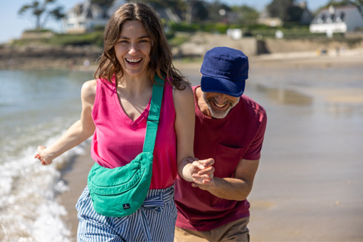 Femme et homme en tenues d'été courant sur la plage