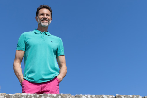 Homme debout portant un polo manches courtes Mousqueton avec un bermuda